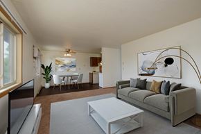 Fargo apartment for rent - a living room with a couch and a coffee table and a dining room and kitchen. Fargo, ND Sargent Apartments