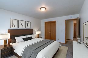 Fargo apartment for rent - a bedroom with a large bed and a closet. Fargo, ND Schrock Apartments