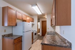 Fargo apartment for rent - a kitchen with white appliances and granite counter tops. Fargo, ND Schrock Apartments