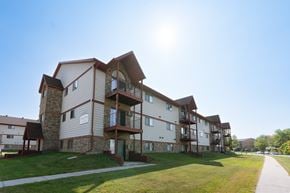 Fargo apartment for rent - The exterior of an apartment with three levels and a sidewalk out front. Fargo, ND Sheridan Pointe Apartment.