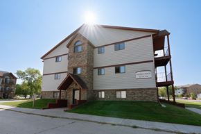 Fargo apartment for rent - An exterior view of an apartment complex with a sidewalk in front of it. Fargo, ND Sheridan Pointe Apartments.