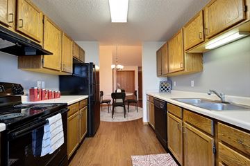 Fargo apartment for rent - Fargo, ND Somerset Apartments. a kitchen with wooden cabinets and black appliances