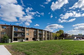 Fargo apartment for rent - The exterior of a three level apartment building with a grass area out front. Fargo, ND South Pointe Apartments