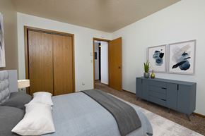 Fargo apartment for rent - a bedroom with a closet, bed, and dresser. Fargo, ND Southwind Apartments