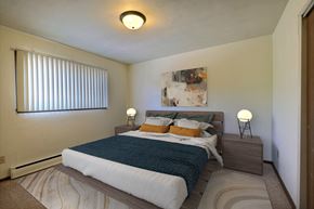 Fargo apartment for rent - a bedroom with a large bed and a window. Fargo, ND Spring Apartments