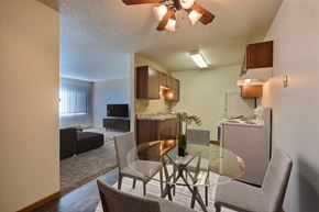 Fargo apartment for rent - a kitchen and dining room with a glass table and chairs. Fargo, ND Sterling Park Apartments