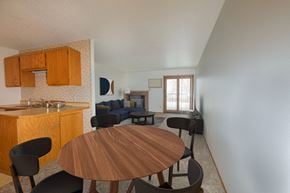 Fargo apartment for rent - a dining area with a table and chairs and a living room with a couch and a fireplace