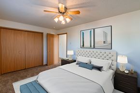 Fargo apartment for rent - a bedroom with a large bed and a ceiling fan. Fargo, ND Sunwood Apartments