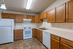 Fargo apartment for rent - a kitchen with white appliances and wooden cabinets.  Fargo, ND Sunwood Apartments  | Living and kitchen Fargo, ND Sunwood Apartments