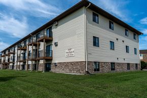 Fargo apartment for rent - The exterior of a three level apartment building with a grass area out front