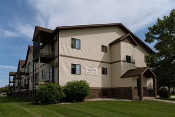 Fargo apartment for rent - the exterior of an apartment building with a lawn and trees