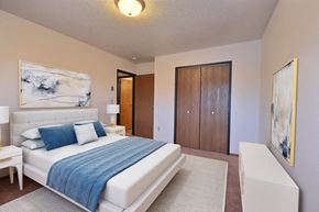 Fargo apartment for rent - a bedroom with a bed and a chair in a room. Fargo, ND Village West Apartments