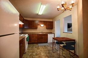 Fargo apartment for rent - a kitchen with white appliances and wooden cabinets. Fargo, ND Westwood Estates Apartments