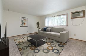 Fargo apartment for rent - a living room with a couch and a coffee table with a window in the back. Fargo, ND White Ridge Apartments