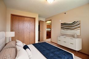 Fargo apartment for rent - a bedroom with a bed and a closet and a bathroom. Fargo, ND Wolf Creek Apartments