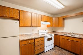 Fargo apartment for rent - a kitchen with white appliances and wooden cabinets. Fargo, ND Brookfield Apartments