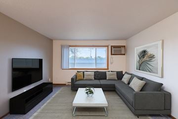 Fargo apartment for rent - a living room with a gray couch and a coffee table and a television