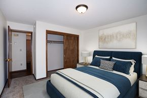 Fargo apartment for rent - a bedroom with a bed and a closet and a door to a bathroom.  Fargo, ND Country Club Apartments