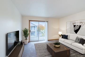 Fargo apartment for rent - an open living room with a white couch and a tv and a sliding glass door