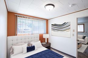 Fargo apartment for rent - a bedroom with a bed and a painting on the wall. Fargo, ND Forest Avenue Apartments