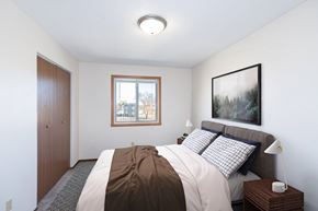 Fargo apartment for rent - a bedroom with a bed and a window. Fargo, ND Hartford Apartments