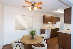 Fargo apartment for rent - a kitchen and dining room with a table and chairs and a ceiling fan. Fargo, ND Hartford Apartments