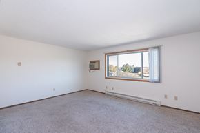 Fargo apartment for rent - an empty living room with a large window and carpet. Fargo, ND Hartford Apartments