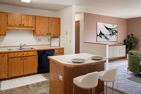 Fargo apartment for rent - a kitchen with a island and a sink and a black dishwasher. Fargo, ND Hunters Run 2 Apartments