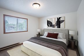 Fargo apartment for rent - a bedroom with a large bed and a window. Fargo, ND Kentwood Manor Apartments