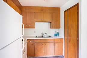 Fargo apartment for rent - a small kitchen with wooden cabinets and a white refrigerator. Fargo, ND Luxford Apartments