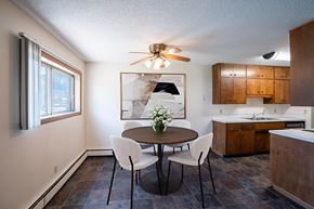 Fargo apartment for rent - a kitchen and dining room with a table and chairs and a ceiling fan. Fargo, ND Martha Alice Apartments