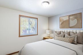 Fargo apartment for rent - a bedroom with a large bed and a window. Fargo, ND Pacific Park Apartments
