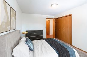 Fargo apartment for rent - a bedroom with a bed and a closet and a door to a bathroom. Fargo, ND Rosegate Apartments