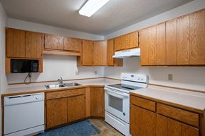 Fargo apartment for rent - an empty kitchen with white appliances and wooden cabinets. Fargo, ND Westview Towers Apartments