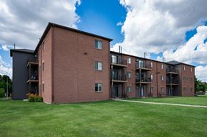 Fargo apartment for rent - a large brick apartment building with a green lawn