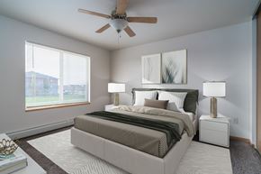 Grand Forks apartment for rent - a spacious bedroom with a ceiling fan and a bed. Grand Forks Desoto Estates