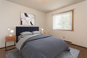 Grand Forks townhouse for rent - Grand Forks, ND Autumn Apartments. A bedroom with a bed and two night stands with a window