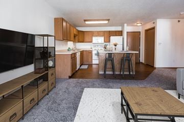 Grand Forks townhouse for rent - an open kitchen and living room with wooden cabinets and a table