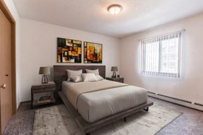 Grand Forks townhouse for rent - Grand Forks, ND Autumn Ridge Apartments. A bedroom with a bed and two nightstands with a window.