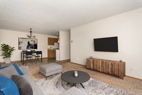 Crookston apartment for rent - Grand Forks, ND Barrette Arms Apartments. a living room with a couch a table and a chair and a television on the wall