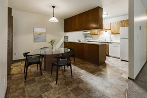 Grand Forks townhouse for rent - Grand Forks, ND Carling Manor Apartments.  a dining area with a table and chairs and a kitchen in the background