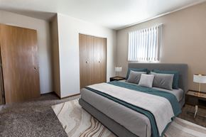Grand Forks apartment for rent - Grand Forks, ND Cherry Creek Apartments. A bedroom with a bed and a wardrobe with a window