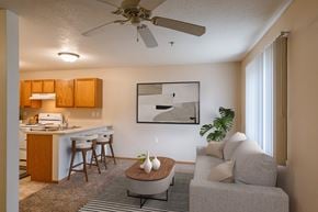 Grand Forks apartment for rent - A living room with a couch and a table in front of a kitchen. Grand Forks, ND Creekside Apartments.