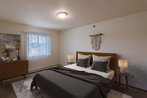Grand Forks apartment for rent - A bedroom with a bed and a dresser and a window. Grand Forks, ND Creekside Apartments.