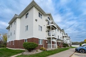 Grand Forks apartment for rent - Grand Forks, ND Creekside Apartments. A white apartment building with a sidewalk in front of it