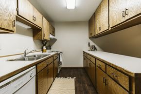 Grand Forks apartment for rent - Grand Forks Harrison Apartments. kitchen with wooden cabinets and white appliances and a sink