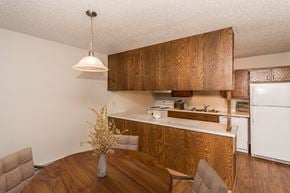 Grand Forks apartment for rent - Grand Forks Kremer Apartments. A dining room with a four-chair table and a kitchen in the background