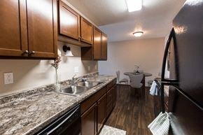 Grand Forks apartment for rent - Grand Forks, ND Library Lane Apartments a kitchen with brown cabinets and granite countertops