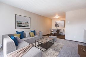 Grand Forks apartment for rent - Grand Forks, ND Library Lane Apartments a living room with a couch coffee table and dining room table in the background