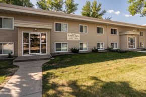Grand Forks apartment for rent - Goldmark's Louise building with a lawn and walkway in front of it